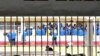 Des détenus à la prison de Makala à Kinshasa, en République Démocratique du Congo, le 18 décembre 2012, derrière les barreaux des fenêtres d'une salle d'audience. (Photo AFP/ Junior D. Kannah)