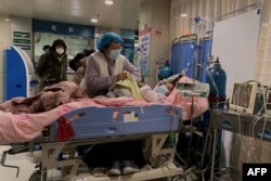 天津第一中心醫院的醫護人員在護理一名感染新冠的病人。（2022年12月28日）