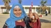 Une électrice tunisienne montre son doigt taché d'encre après avoir voté lors des élections législatives, dans un bureau de vote du district de Mnihla, à l'extérieur de Tunis, le 17 décembre 2022.