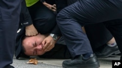 上海警察把一名抗議中國嚴厲防疫政策的青年壓倒在地。 （2022年11月27日）