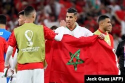 Des joueurs marocains déploient le drapeau national à l'issue de leur match contre la Belgique.