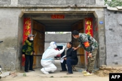 中國河南省夏邑縣的醫護人員上門給居民做核酸檢測。（2022年5月10日）