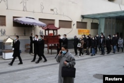 四川成都一個火葬場工作人員抬著一名逝者的骨灰盒走出火葬場。(2022年12月28日)