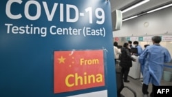 南韓仁川國際機場的醫護人員為從中國抵達的乘客進行核酸檢測。（2023年1月3日）