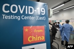 仁川國際機場的醫護人員為從中國抵達的乘客進行核酸檢測。（2023年1月3日）