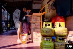An employee prepares cooking oil which used to fry tempe chips, a traditional Indonesian food made from fermented soybeans, in Jakarta May 18, 2022.