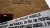 FILE - Signs prohibiting guns are displayed outside the Uvalde Consolidated Independent School District board room, where officials gave an update in the wake of the shooting at Robb Elementary, June 9, 2022, in Uvalde, Texas. 