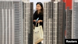 資料照：湖北武漢一名女子正在一個新樓盤售樓處觀看。