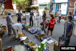 2022年9月5日，中國新疆維吾爾自治區烏魯木齊市天山區的居民在水果攤位前排隊購物