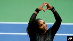 La star américaine du tennis Serena Williams fait un signe du cœur à ses fans après avoir perdu contre l'Australienne Ajla Tomljanovic, lors du troisième tour de l'US Open de tennis, le 2 septembre 2022, à New York.