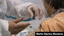 Une femme reçoit une dose du vaccin anti-covid chinois Sinopharm à Belgrade, en Serbie, le 21 janvier 2021. REUTERS/Marko Djurica