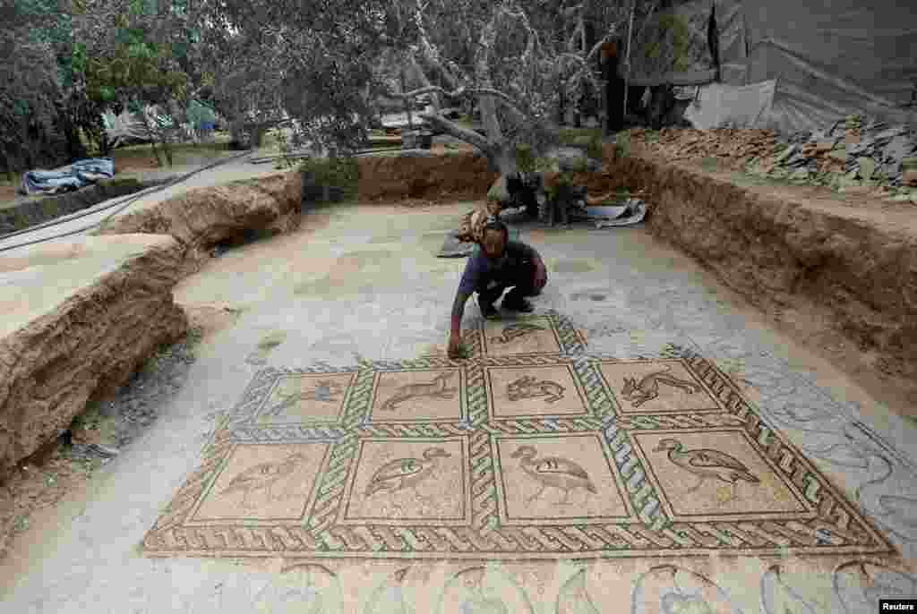 កសិករប៉ាឡេស្ទីនលោក Salman al-Nabahin សម្អាតឥដ្ឋការ៉ូរចនាដោយក្បាច់ Mosaic ដែលលោកបានប្រទះឃើញនៅកសិដ្ឋានរបស់លោក នៅភាគកណ្តាលតំបន់ Gaza Strip និងដែលមានអាយុកាលចាប់តាំងពីសម័យ Byzantine មក បើយោងទៅតាមមន្ត្រីពាក់ព័ន្ធ។