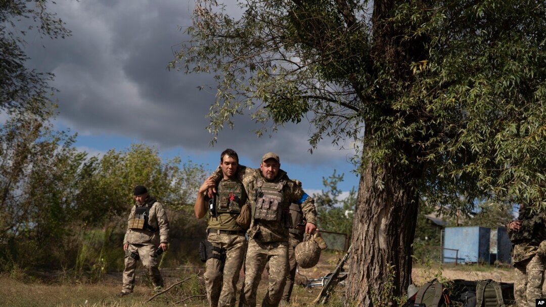 Un militar ucraniano ayuda a un compañero durante una evacuación de soldados heridos que participan en la contraofensiva en una región cercana a la aldea recuperada de Shchurove, Ucrania, el 25 de septiembre de 2022.