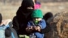 A Syrian woman and a child, evacuated from the city of Aleppo arrive at a refugee camp in Rashidin, near Idlib, Syria, Dec. 19, 2016. A plan, so far opposed by Damascus, envisions the creation of civilian safe zones in northern parts of Syria.