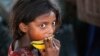 FILE - A child laborer eats a piece of a muskmelon on the World Day against Child Labor on the outskirts of Jammu, India, June 12, 2015.