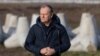 Polish Prime Minister Donald Tusk addresses reporters with concrete antitank barriers in the background during his inspection of the first completed section of fortifications on the Polish-Russian border near Dabrowka, Poland, on Nov. 30, 2024.