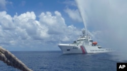 2015年9月23日，中國一艘海警船在南中國海黃岩島附近接近菲律賓的一艘漁船。 （資料照片）