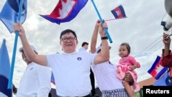 FILE - Vice President of Candlelight Party, Son Chhay, waves flags during a campaign rally for the upcoming local elections on June 5, in Phnom Penh, Cambodia May 21, 2022. 