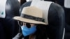 A woman wears a protective mask onboard during a flight of Bamboo Airways from Da Nang to Hanoi, Vietnam March 7, 2020. REUTERS/Kham