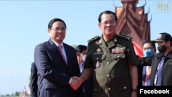 លោកនាយករដ្ឋមន្ត្រី ហ៊ុន សែន ចាប់ដៃជាមួយលោក Pham Minh Chin នាយករដ្ឋមន្ត្រីវៀតណាមនៅក្នុងពិធីប្រារព្ធខួបលើកទី៤៥ឆ្នាំនៃ«ដំណើរឆ្ពោះទៅរកការតស៊ូរំដោះជាតិ»ពីរបប ប៉ុល ពត» នៅខេត្តត្បូងឃ្មុំ ថ្ងៃទី២០ ខែមិថុនា ឆ្នាំ២០២២។ (Facebook/Cambodian PM Hun Sen)