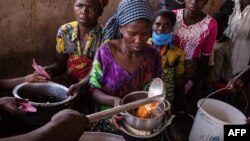 Des réfugiés de la RDC reçoivent un déjeuner au centre de transit de Nyakabande à Kisoro, en Ouganda, le 7 juin 2022.