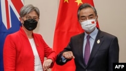 2022年7月8日，在印尼度假勝地巴厘島努沙杜瓦舉行的二十國集團外長會議期間，澳大利亞外交部長黃英賢(左)與中國外交部長王毅碰肘互致問候。