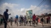 Des manifestants portent une affiche honorant les forces armées de la RDC lors d'une manifestation à Goma, le 15 juin 2022.