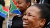 People hold South African flags as Nelson Mandela Foundation CEO Sello Hatang speaks to the press on the steps of the Johannesburg High Court, Aug. 21, 2019, after South Africa's Equality Court restricted the display of the old apartheid-era flag.