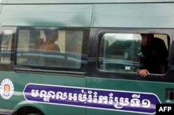លោក​ យាង​ សុធារិន និង​លោក​អ៊ួន ឈិន អតីត​អ្នកសារព័ត៌មាន​វិទ្យុអាស៊ីសេរី ដែល​ត្រូវ​បាន​រងការ​ចោទ​ប្រកាន់​ពី​បទ​ចារកម្ម​ អង្គុយ​នៅ​ខាង​ក្នុង​រថយន្ត​ប៉ូលិស​ ខណៈ​ពេល​អ្នក​ទាំងពីរ​មក​ដល់​សាលាឧទ្ធរណ៍​ កាល​ពី​ថ្ងៃ​ទី១៩ ខែ​មេសា ឆ្នាំ​២០១៨។