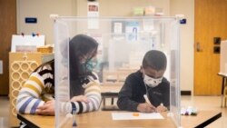 Mësuesja Sarah McCarthy ndihmon një nxënës në shkollën fillore Dawes Elementary në Çikago (11 janar 2021)