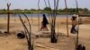 FILE - Chadian women walk past destroyed homes, in the Lake Chad shore village of N'Gouboua, March 5, 2015, following a scorched-earth attack by Boko Haram militants.