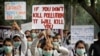 FILE - Schoolchildren hold banners to express their distress at the alarming levels of pollution in the city, in New Delhi, India, Nov. 15, 2017.