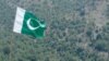 FILE - A Pakistani flag flies at Manatu mountain in the central part of Kurram Agency, Pakistan's tribal belt bordering Afghanistan, July 10, 2011. 