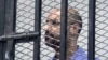 FILE - Saif al-Islam Gadhafi, son of Libya's former stongman Moammar Gadhafi, is shown inside a courtroom cage, Zintan, Sept. 19, 2013.
