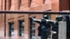 Police officers gesture near Lindt cafe in Martin Place, where hostages are being held, in central Sydney, December 15, 2014.