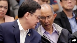Former chief of the Philippine National Police Criminal Investigation and Detection Group (PNP-CIDG) and now Mayor Benjamin Magalong, right, talks to Justice Secretary Menardo Guevarra at the resumption of the Senate probe on the release of hundreds…