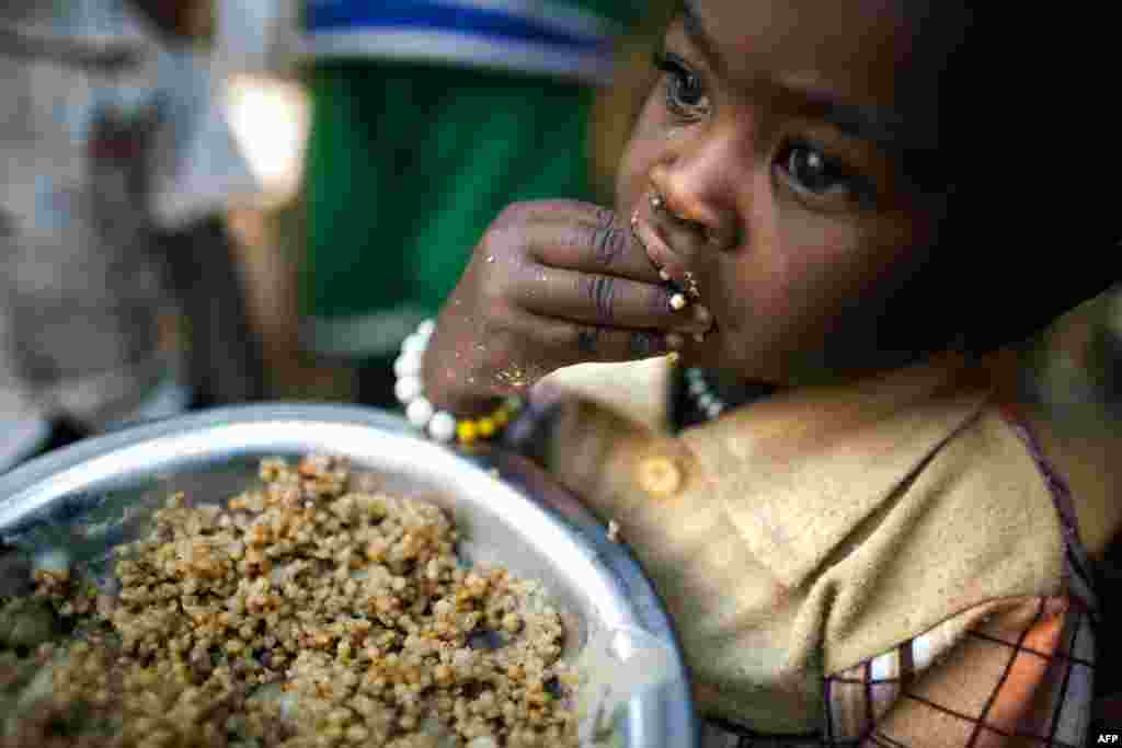 Un enfant mange des lentilles dans un centre de distribution alimentaire dans camp pour les déplacés à l'intérieur (IDP) à Tawila, Darfour-Nord. AFP PHOTO / MINUAD / ALBERT GONZALEZ FARRAN