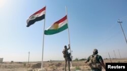 Un membre des forces de sécurité irakiennes descendant le drapeau kurde à Kirkouk, Irak, le 16 octobre 2017.