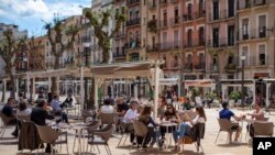 Des clients assis boivent sur un bar en terrasse à Tarragone, en Espagne, à la faveur du début du déconfinement, le 11 mai 2020.