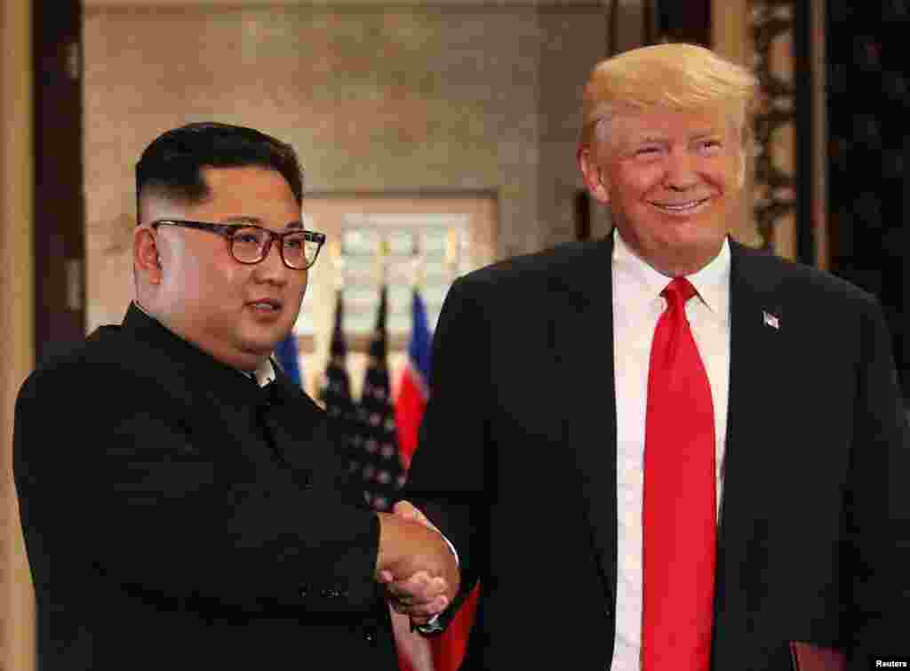 Shugaban Amurka Donald Trump da shugaban Koriya Ta Arewa Kim Jong Un suna shan hannu bayan sa hannu a yarjejeniya a taron kolin da suka gudanar a otel din Capella Hotel dake tsibirin Sentosa, Singapore, Juni 12, 2018.