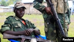 Waasi wa M23 wakiwa karibu na sehemu iliyowekwa kizuizi cha wamajeshi wa umoja wa mataifa, Kanyaruchinya, kaskazini mwa Goma. May 15,2013