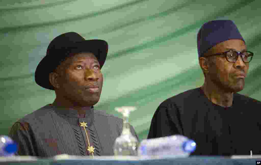 Le candidat de l'opposition, le général Muhammadu Buhari, à droite, et le président Goodluck Jonathan du Nigeria, à gauche, se préparent à renouveler leur engagement à organiser des élections pacifiques "libres, justes et crédibles", dans un hôtel de la capitale Abuja, Nigeria jeudi 26 mars 2015. 