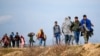 Des migrants marchent sur une route près du poste frontière d'Ipsala à Edirne, à la frontière turco-grecque, le 3 mars 2020.