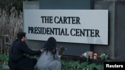 Waombolezaji wakiweka mashada ya maua katika kituo cha Rais Jimmy Carter, baada ya kutangazwa kifo cha chake, Jumapili, Desemba, 29, 2024.