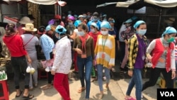 Garment workers leave the Propitious (Cambodia) Garment Ltd. factory for a lunch break in Kandal province, Cambodia, March 20, 2020. (Kann Vicheika/VOA Khmer)