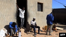 Les migrants africains s'installent au soleil dans une maison sécurisée dans la ville de Bani Walid, à la lisière du désert, à 170 kilomètres au sud-est de la capitale libyenne, Tripoli, le 12 décembre 2017.