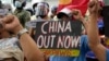 在海牙国际仲裁庭就菲律宾与中国海洋权利纠纷作出裁决五周年之际，抗议者举着标语在中国驻菲律宾马卡蒂领事馆外集会。(2021年7月12日)