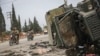 Syrian opposition fighters drive past a damaged government vehicle south of Hama, Syria, Dec. 7, 2024.
