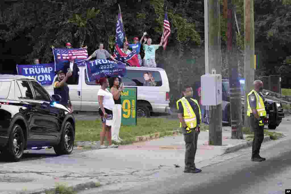 អ្នកគាំទ្រលោក Donald Trump លើកបដានិងគ្រវីទង់នៅខាងក្រៅពន្ធនាគារស្រុក Fulton ក្រុង Atlanta រដ្ឋ Georgia កាលពីថ្ងៃទី២៤ ខែសីហា ឆ្នាំ ២០២៣។