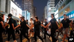 香港蒙面示威人士10月5日傍晚手拉手，抗議政府禁蒙面規例實施。